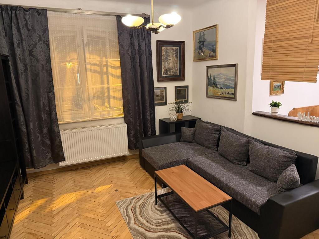 salon z kanapą i stołem w obiekcie Apartments & Restaurant Tkalcovsky dvur w Pradze