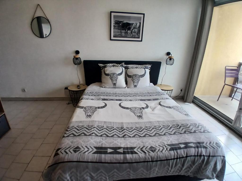 une chambre avec un lit avec une couverture dessus dans l'établissement Studio clim parking dhuoda, à Nîmes