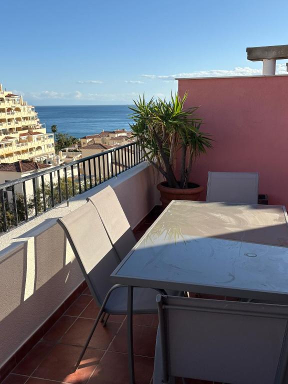 a balcony with a table and chairs and the ocean at El Ático de Brisaquebrada - Vista Mar - Gran Terraza in Benalmádena