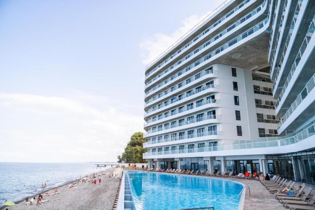 a hotel with a swimming pool next to the beach at Bamboo Beach Tsikhisdziri! Enjoy your stay! in Tsikhisdziri