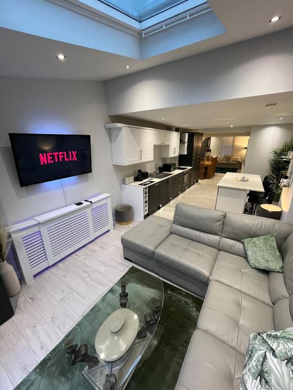 a living room with a couch and a tv at Luxury Seaside Town House in Bangor