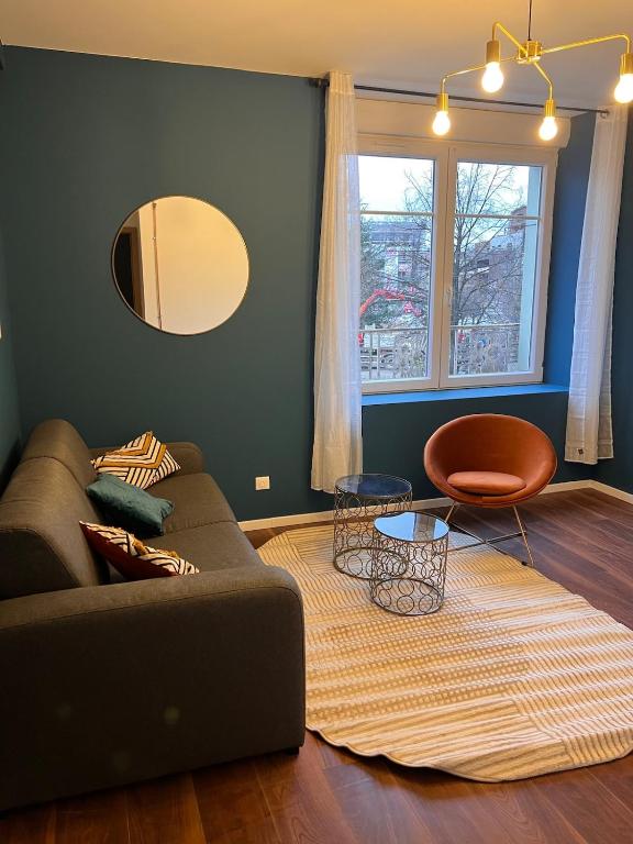 un salon avec un canapé et un miroir dans l'établissement L'élegant Belfortain, à Belfort