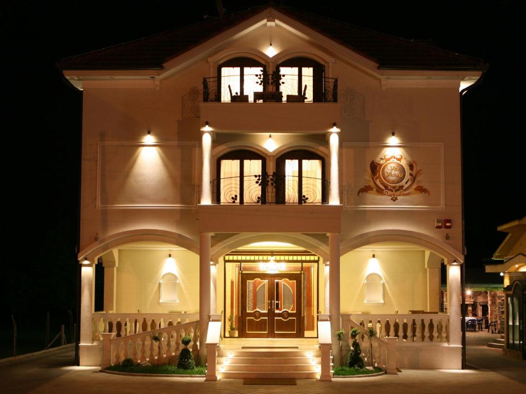 a large building with a front door at night at Hotel Villa Viktorija in Banja Luka