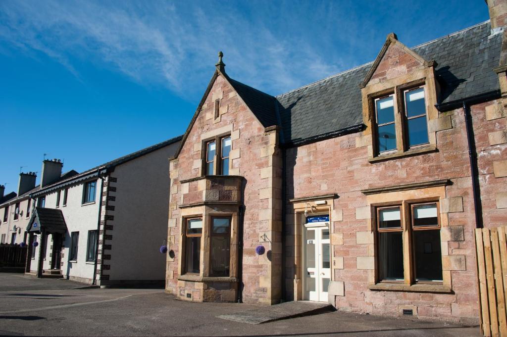 un viejo edificio de ladrillo con una cruz encima en Alban and Abbey House, en Inverness