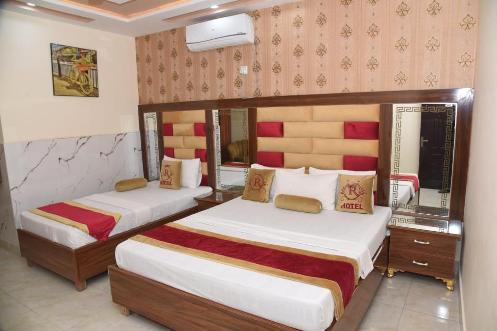a hotel room with two beds and a mirror at Grace one hotel in Lahore