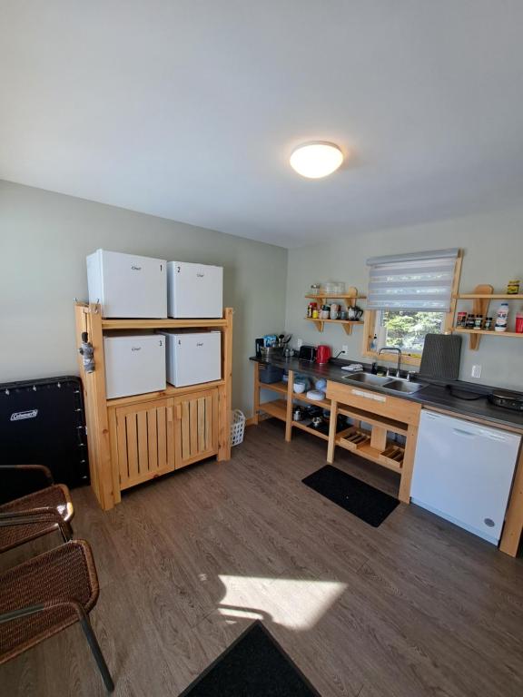 a room with a kitchen with a desk and refrigerator at The Zzzz Moose Camping Cabins in Birch Plain