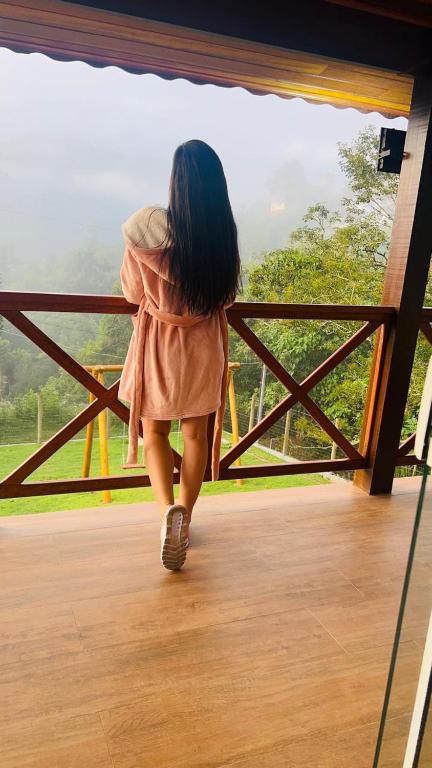 a young girl is walking on a porch at A Casa do Júnior em Visconde de Mauá in Visconde De Maua