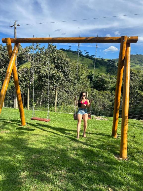 a woman sitting on a swing in a park at A Casa do Júnior em Visconde de Mauá in Visconde De Maua