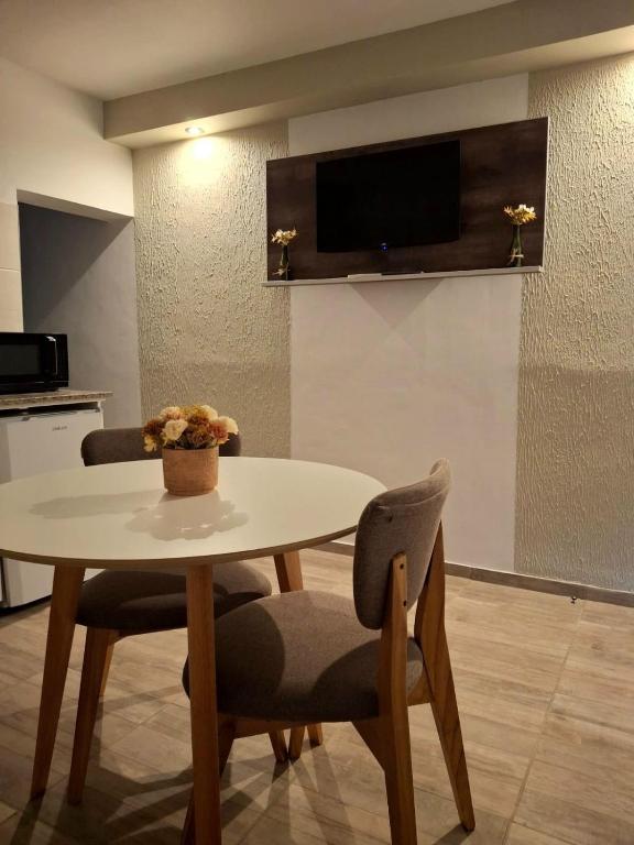 a table and chairs in a room with a tv at Rincón de paso in Ciudad Lujan de Cuyo