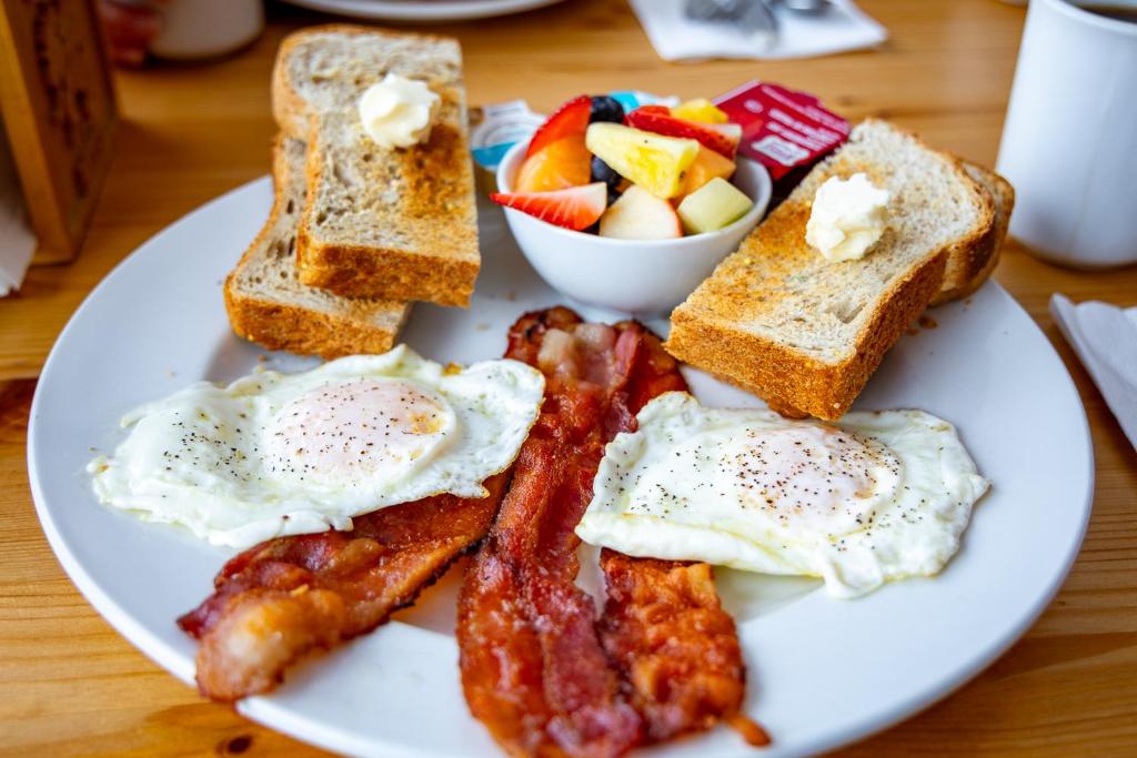 a plate of breakfast food with eggs bacon and toast at The Zzzz Moose Camping Cabins in Birch Plain