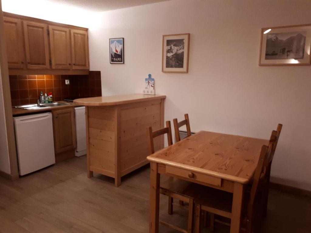 une cuisine avec une table en bois et une table et des chaises dans l'établissement T1 Les 2 Alpes Le Kandahar, à Les Deux Alpes