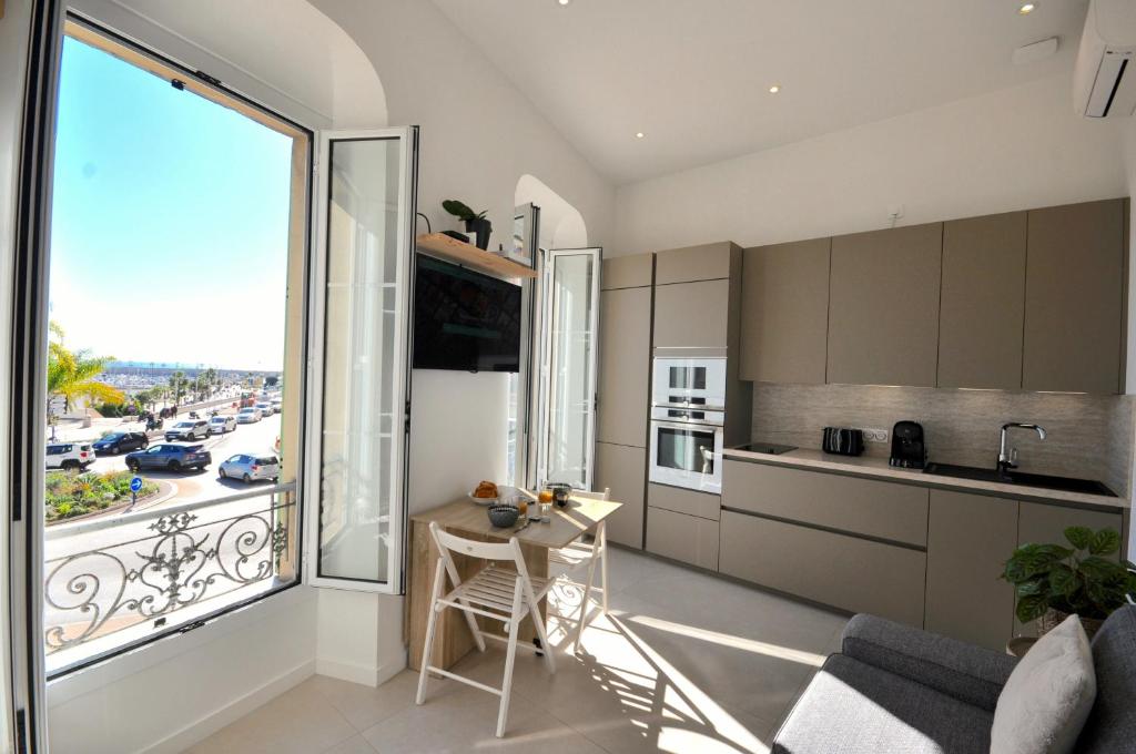 una cucina e un soggiorno con una grande finestra di MENTON # MONACO - F1 GP - 4 PERSONS - SEA VIEW - NEW - PARKING - CLIM - PREMIUM - BEACH and SUN a Mentone