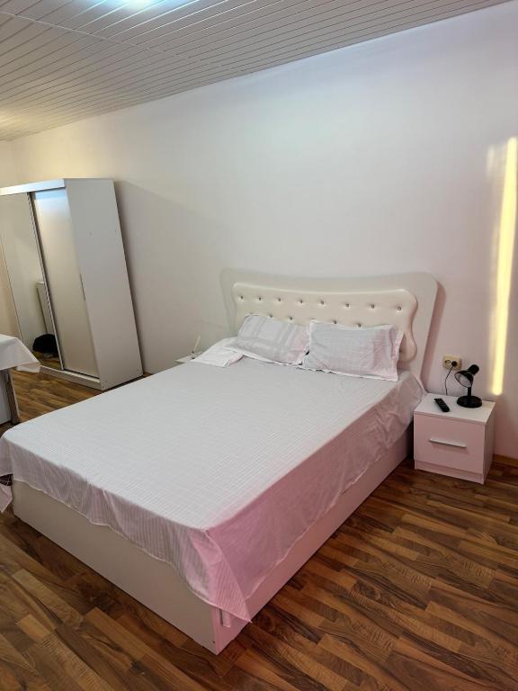 une chambre avec un grand lit blanc avec des draps blancs dans l'établissement Garsoniera la vila, à Jilava