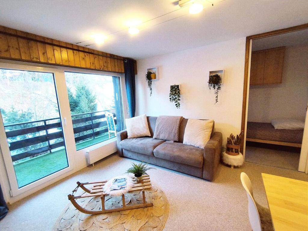 a living room with a couch and a table at Chalet Alpin, central et parking in Veysonnaz