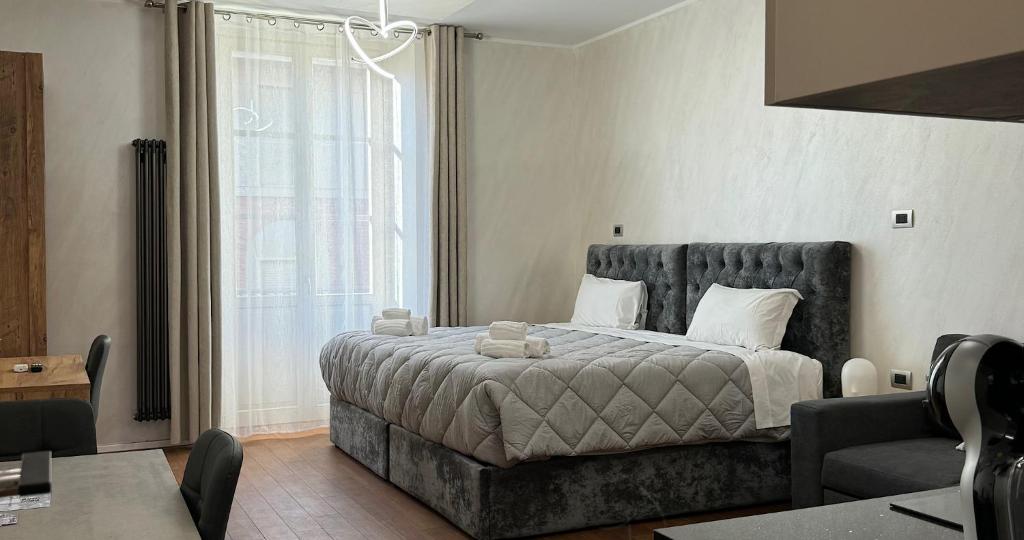 Un dormitorio con una cama con una ventana grande. en APARTAMENT - Torino Home Living, en Turín