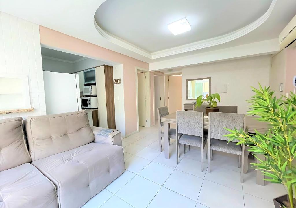 ein Wohnzimmer mit Couch und Tisch in der Unterkunft 2 quartos, suíte, perto do mar, com ar e garagem! in Capão da Canoa