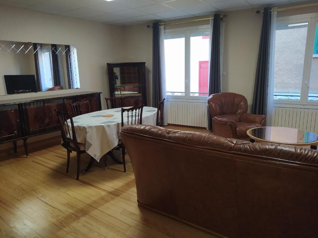 un salon avec un canapé, une table et des chaises dans l'établissement Grand T2 Hypercentre, rue calme, à Ax-les-Thermes