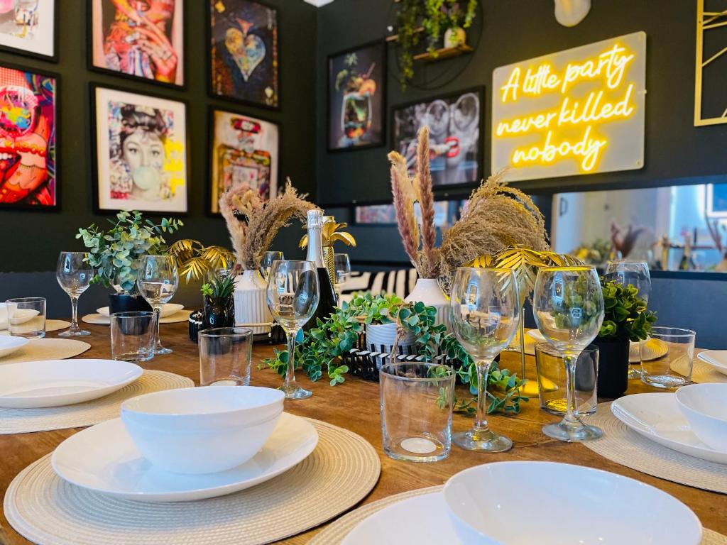 a table with plates and wine glasses on it at Stag Do accommodation, central Bournemouth in Bournemouth