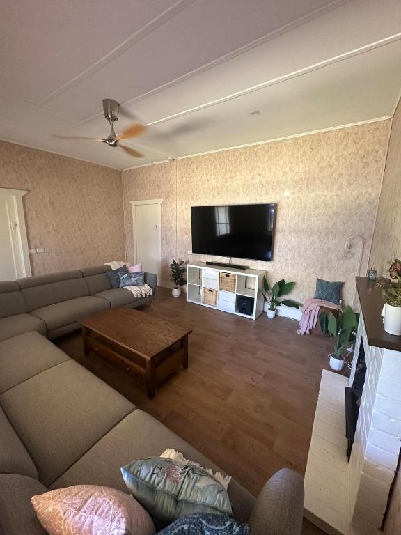 a living room with a couch and a flat screen tv at Cottage in Barmera in Barmera