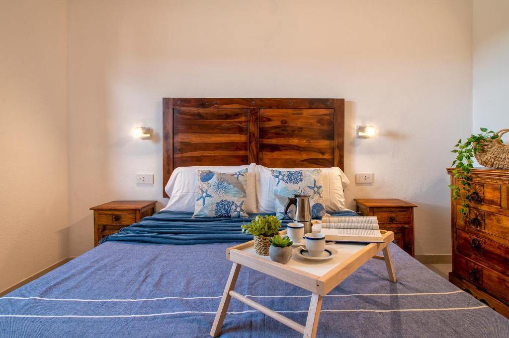 een slaapkamer met een bed met een houten hoofdeinde en een tafel bij HD Apartment San Teodoro Center in San Teodoro