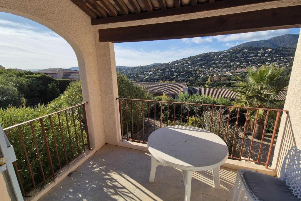 d'une table et d'une chaise blanches sur un balcon avec vue. dans l'établissement Beautiful apt with balcony in Cavalaire-sur-Mer, à Cavalaire-sur-Mer