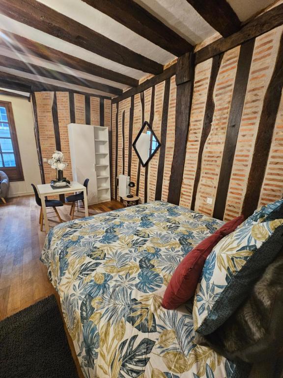une chambre avec un lit dans une pièce aux murs en bois dans l'établissement Petit havre de paix - quartier historique, à Tours