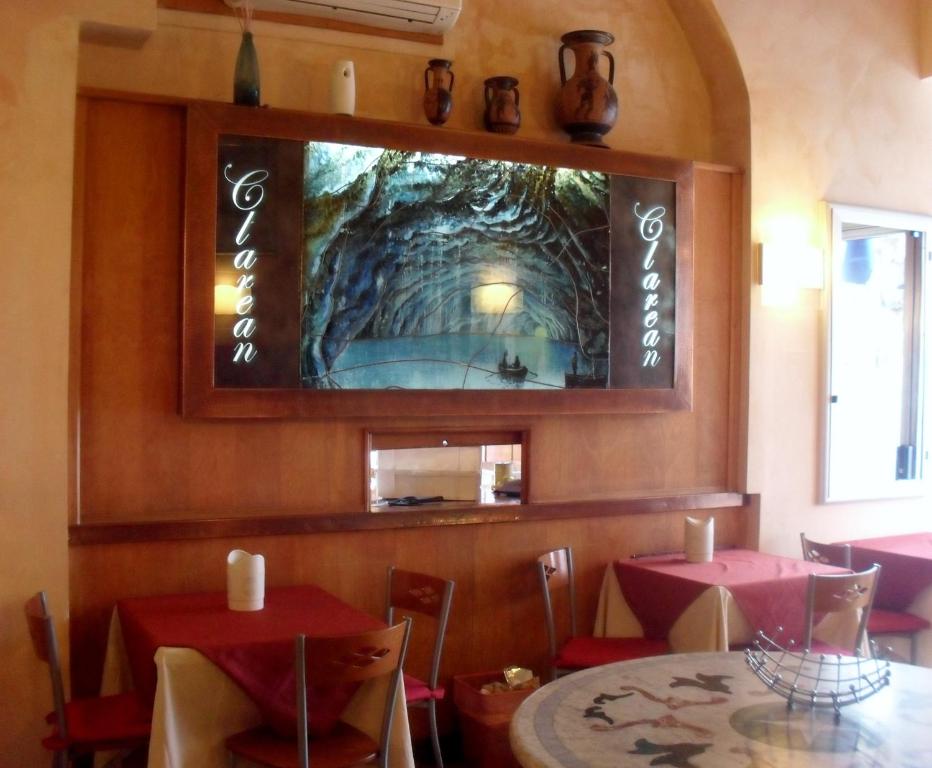 a dining room with a table and a tv on the wall at Hotel Clarean in Naples