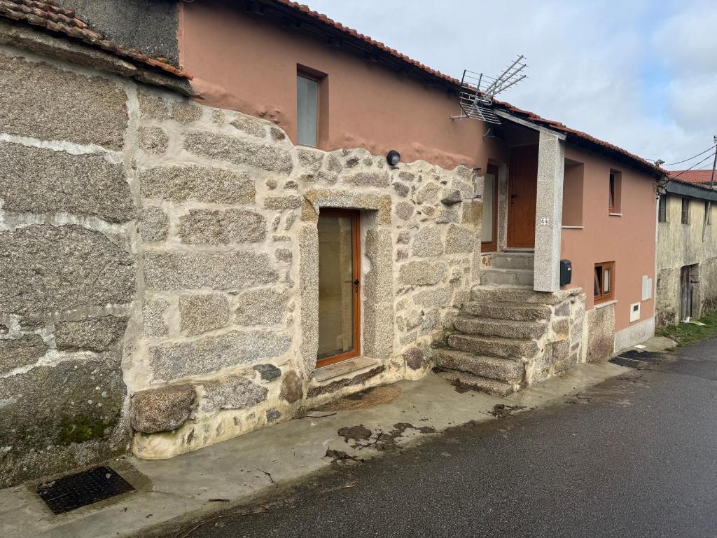 an old stone building with stairs next to a street at Casa Morgade in Montalegre