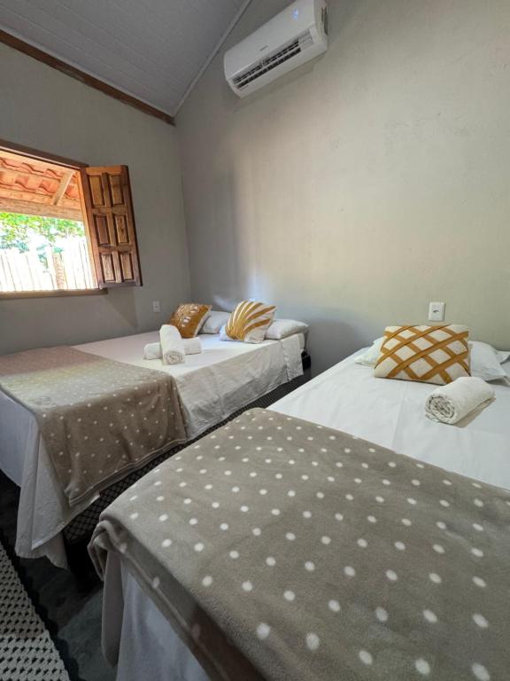 een kamer met twee bedden en een raam bij Vila Kairós in Caraíva