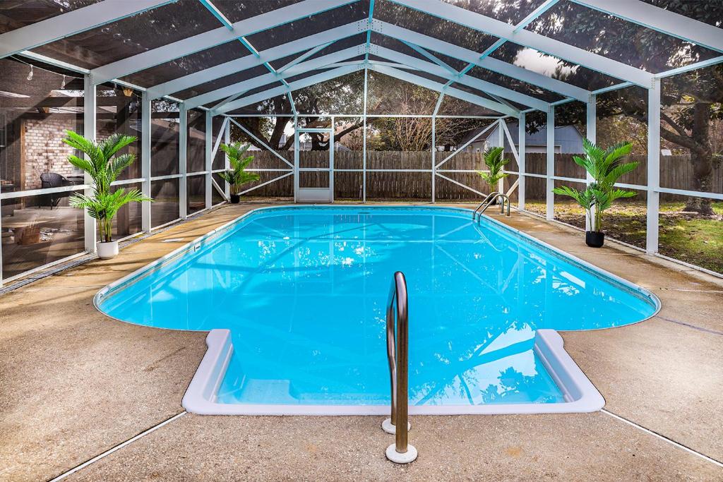 a large swimming pool in a building with a roof at Pool House, Short Drive to Beach, Grill, Smart TV in Navarre