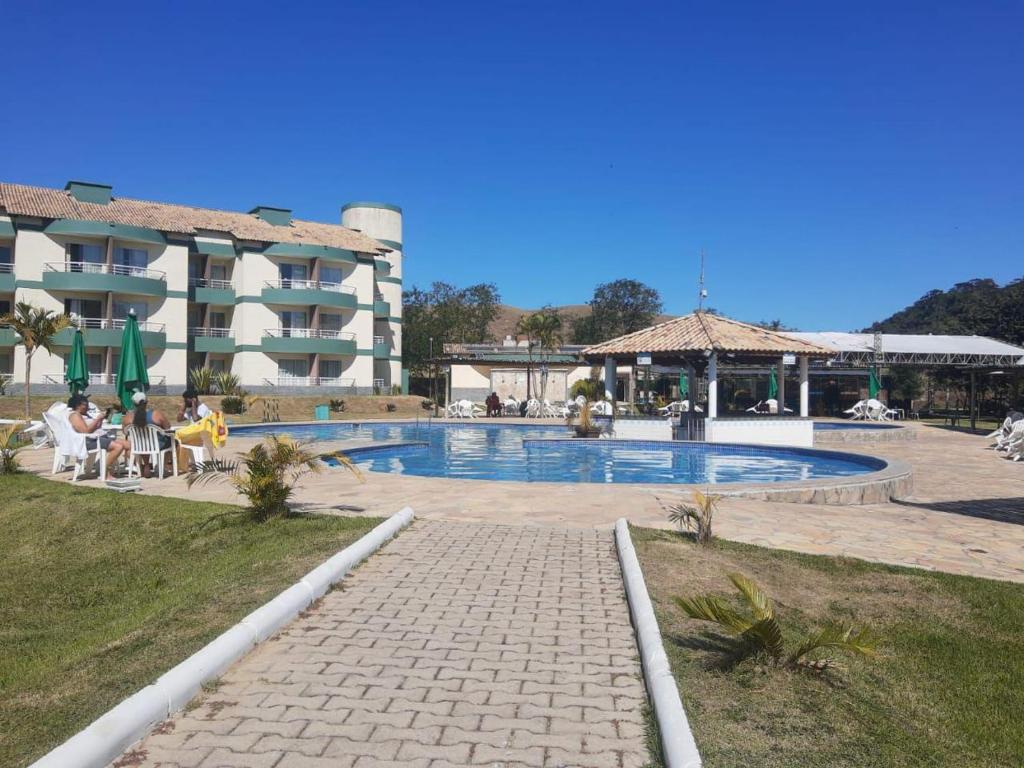 a hotel with a swimming pool in front of a building at Flat Village - Aldeia das Águas D301 in Barra do Piraí