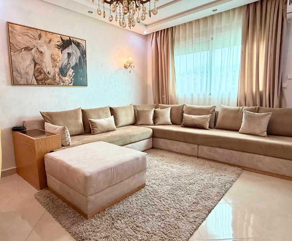 a living room with a large couch and a table at The Paradise of ACHAKAR in Tangier