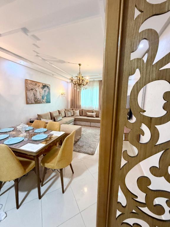a dining room and living room with a table and chairs at The Paradise of ACHAKAR in Tangier