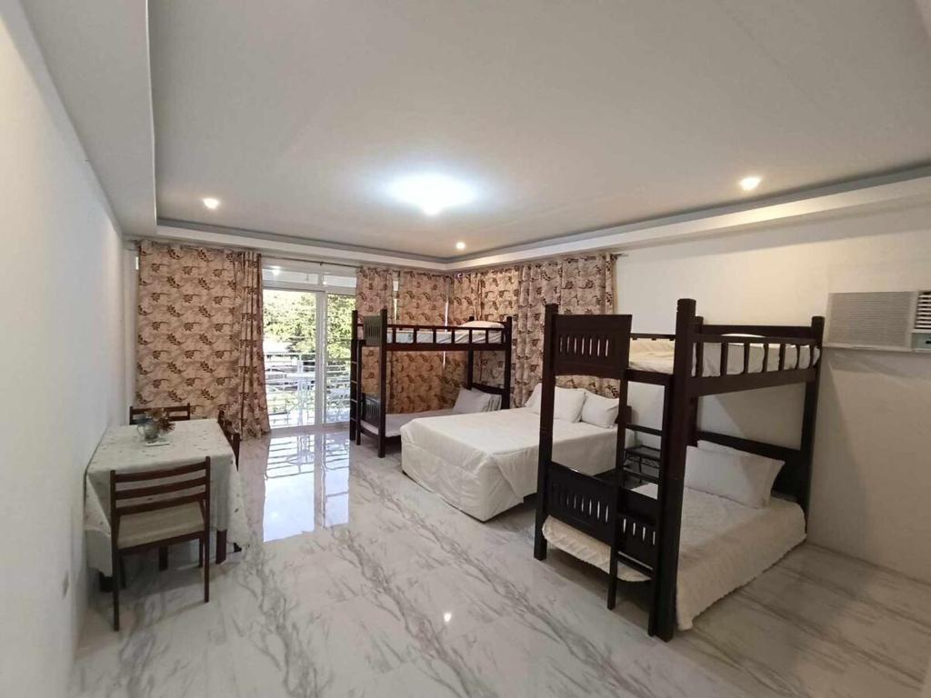 a bedroom with two bunk beds and a table at La Casa Cita in Indang