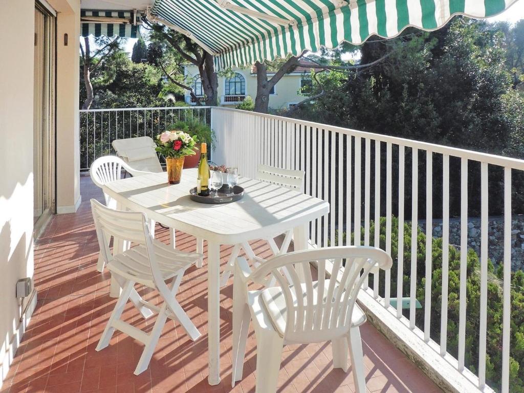 une table et des chaises blanches sur une terrasse avec un parasol dans l'établissement Apartment in Antibes near Sandy Beach, à Antibes