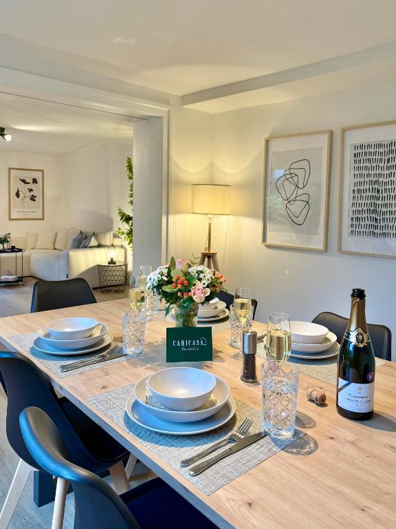 a dining table with plates and a bottle of wine at CARICASA: Bielefeld Mitte in Bielefeld