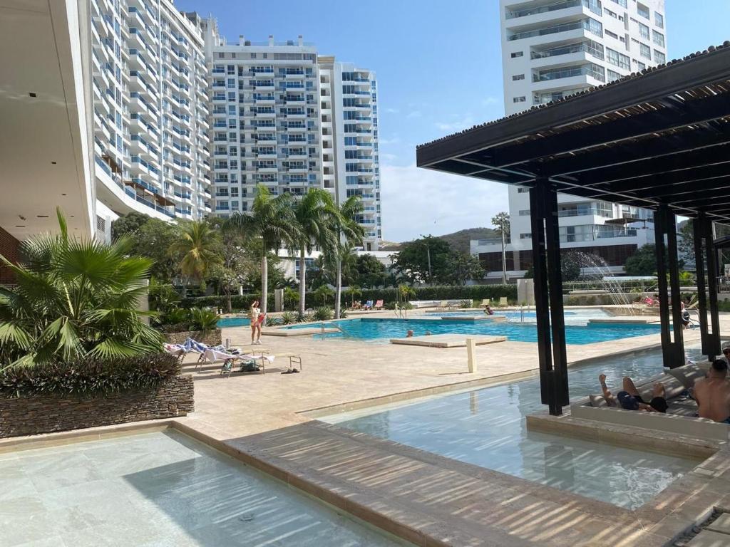 a swimming pool in a city with tall buildings at Condominio Reserva del mar Santa Marta in Gaira