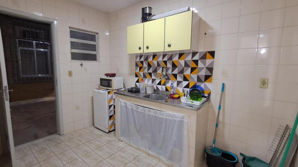 eine kleine Küche mit Spüle und Mikrowelle in der Unterkunft Casa na melhor localização de Santa Teresa in Rio de Janeiro