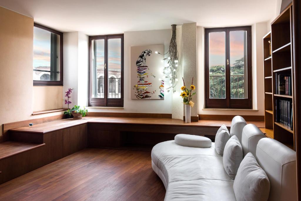 een woonkamer met een witte bank en ramen bij Dimore Verona 2 in Verona