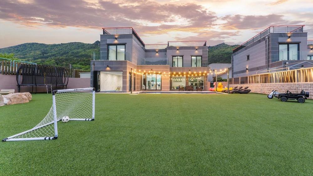 a house with a soccer ball on a grass field at Pause Kids Pool Viila A in Yeosu