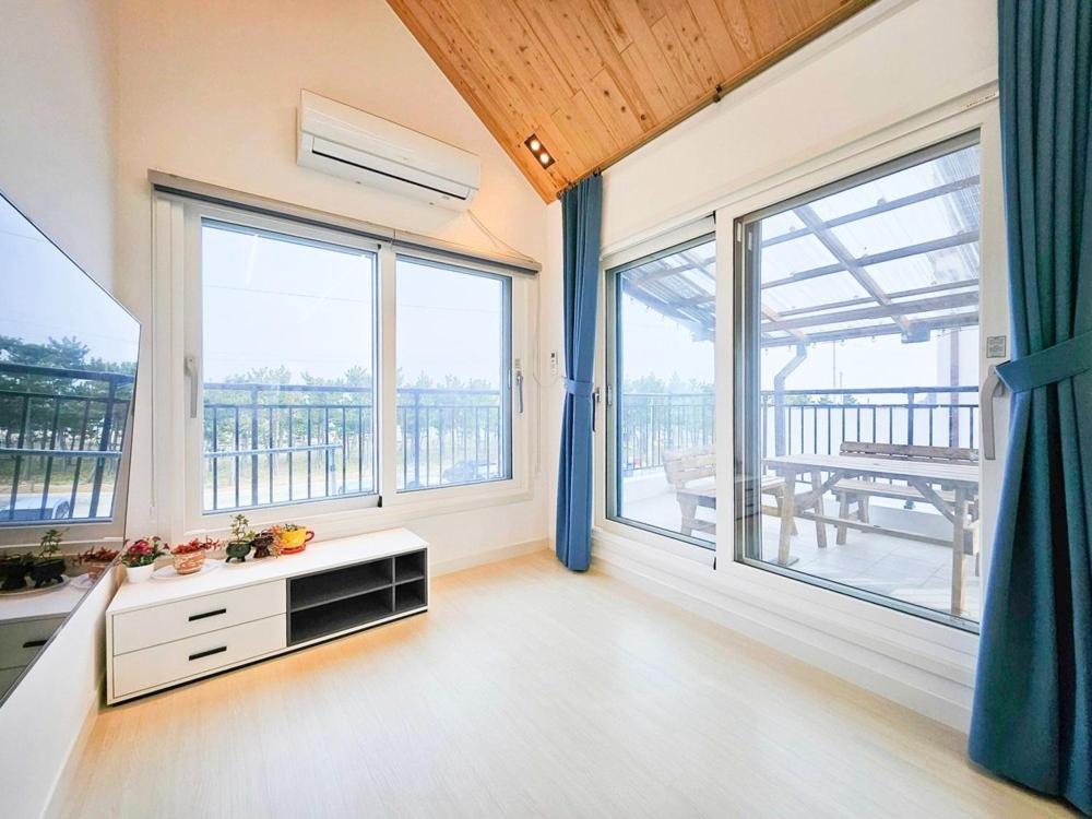 a living room with large windows and a table at Uljin Jeongdam-eun Ocean View Pension in Uljin