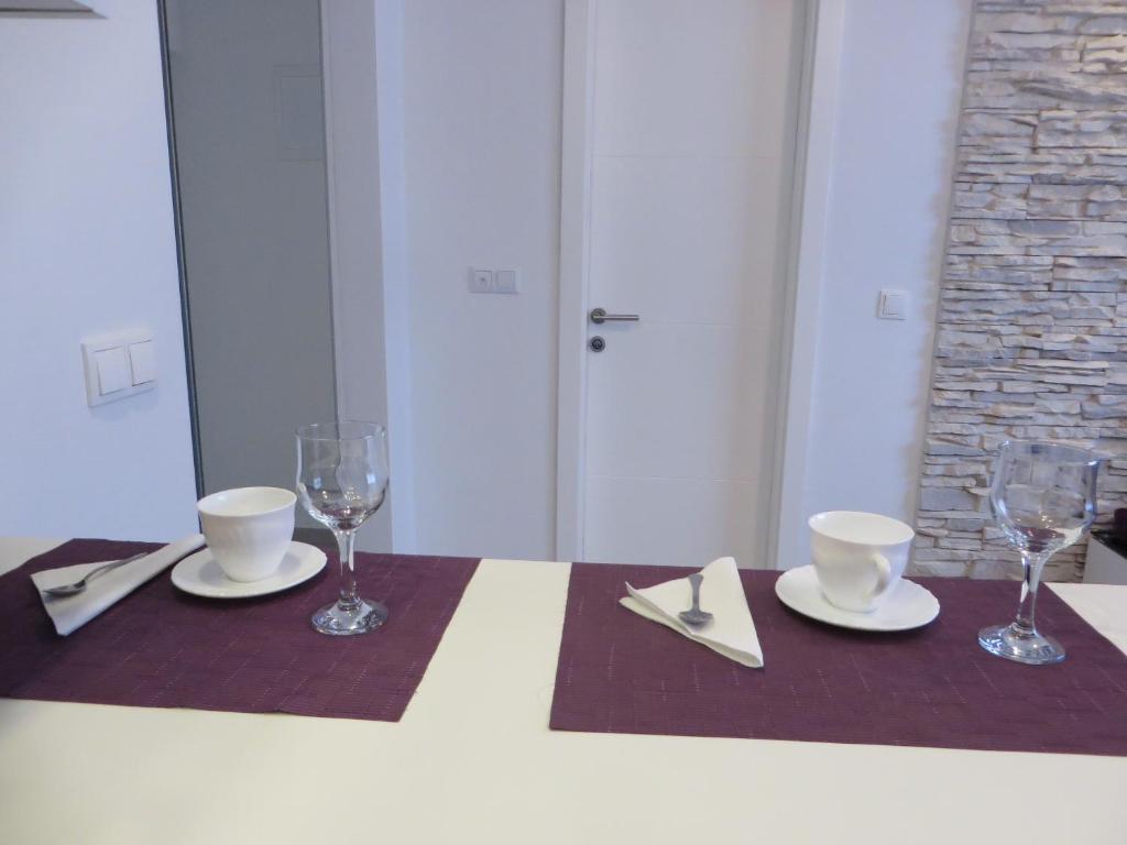 a table with two plates and glasses on it at Sea Gate Studio in Zadar