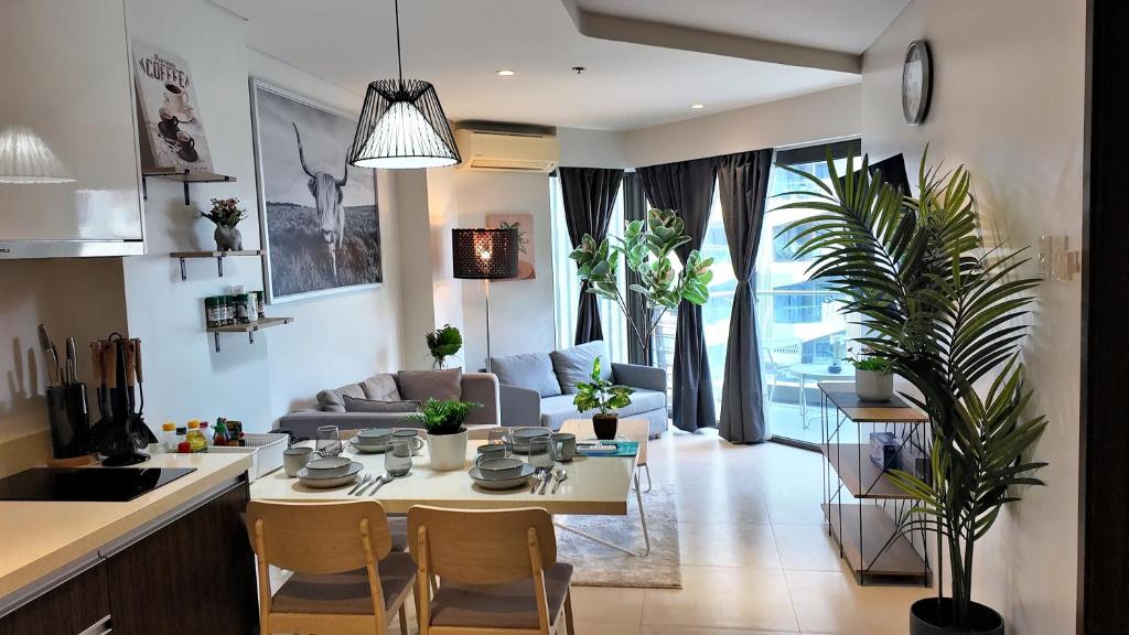 una cucina e un soggiorno con tavolo e sedie di Dominiks spacious classic family VIP 1 Bedroom Tambuli Balcony Pool Beach a Lapu Lapu City