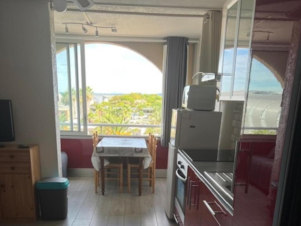 une cuisine avec une table et une vue sur l'océan dans l'établissement Studio avec parking privé à 500m de la plage - FR-1-338-603, à Sète