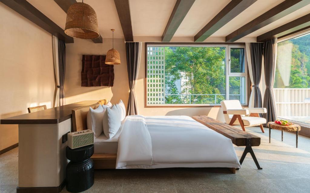 a bedroom with a bed and a large window at Yangshuo One Thousand and One Courtyard Views B&B in Yangshuo