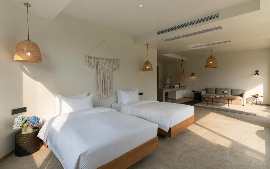 a bedroom with two beds and a living room at Yangshuo One Thousand and One Courtyard Views B&B in Yangshuo