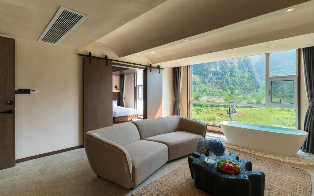 a living room with a couch and a bath tub at Yangshuo One Thousand and One Courtyard Views B&B in Yangshuo