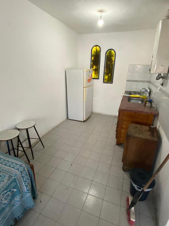 コスキンにあるApartamento El Gauchito en Cosquinのキッチン(冷蔵庫、テーブル、椅子付)