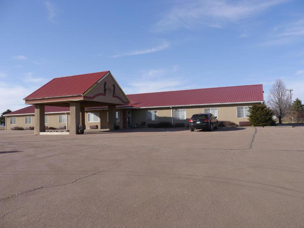 un edificio con techo rojo y aparcamiento en Westwood Inn & Suites - Kimball, en Kimball