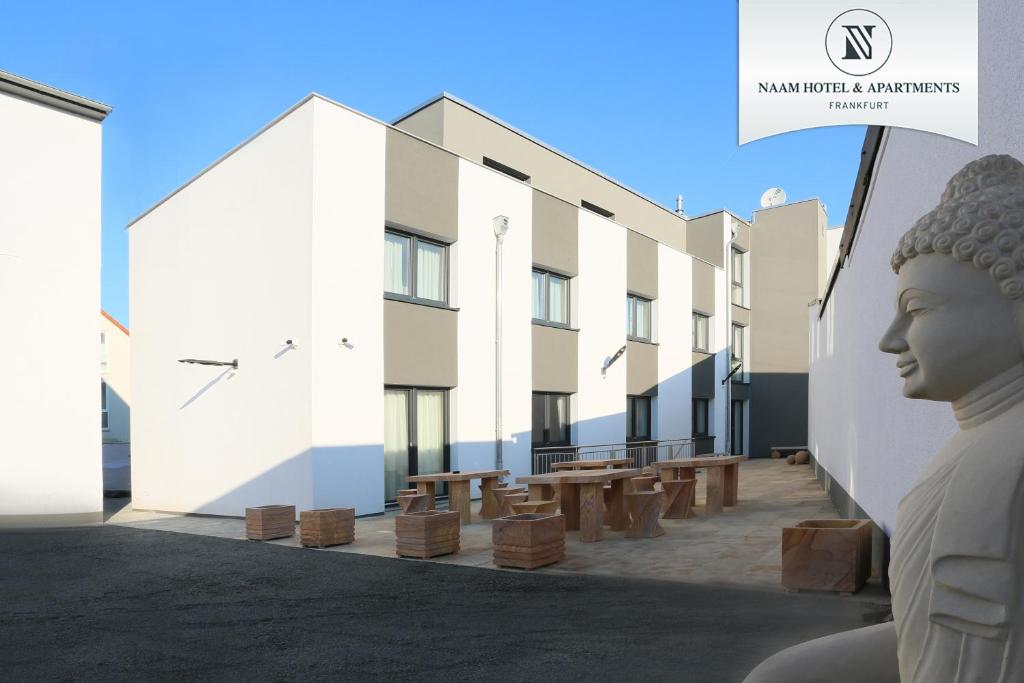 a rendering of a building with a statue in the foreground at Naam Hotel & Apartments Frankfurt City-Messe Airport in Frankfurt/Main